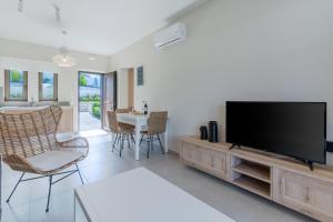 a living room with a flat screen tv on a entertainment center at Plakias Resorts in Plakias