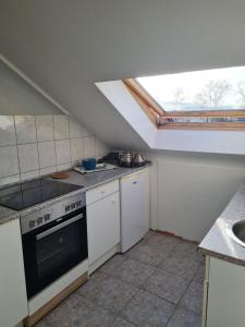 a kitchen with a stove and a skylight at MM Apartment Wesseling in Wesseling