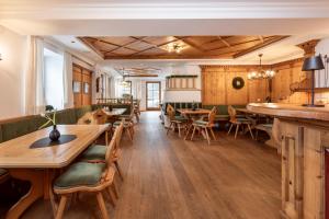 a restaurant with wooden floors and tables and chairs at Obersulzberggut in Radstadt