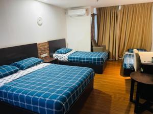 Habitación de hotel con 2 camas y escritorio en Staycity Apartments - Kota Bharu City Point, en Kota Bharu