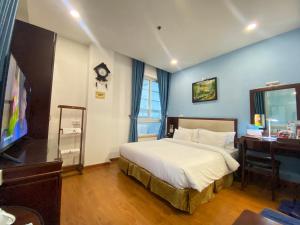 - une chambre avec un lit, un bureau et une télévision dans l'établissement A25 Hotel - 180 Nguyễn Trãi, à Hô-Chi-Minh-Ville