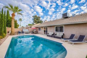 a swimming pool in front of a house with a palm tree at Scottsdale Vacation Rentals in Scottsdale