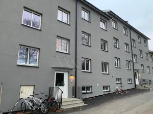 Stabekk的住宿－Room in Stabekk Appartment，一座灰色的建筑,外面停有自行车