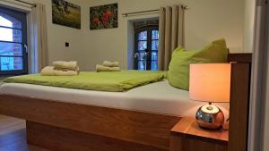 ein Schlafzimmer mit einem Bett mit grüner Bettwäsche und einer Lampe in der Unterkunft FerienRemise in Brandenburg an der Havel