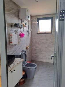 La petite salle de bains est pourvue de toilettes et d'un lavabo. dans l'établissement Nắng house with lake view., à Bảo Lộc