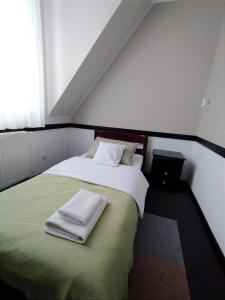 um quarto com uma cama com toalhas em Pensjonat Hagi em Horyniec