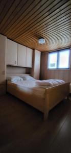 duże łóżko w pokoju z drewnianym sufitem w obiekcie Chalet 182 La Boverie Rendeux - La Roche w mieście Rendeux