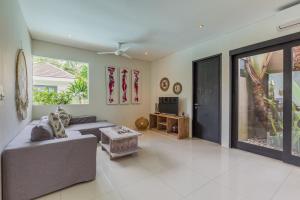 a living room with a couch and a tv at Beautiful Huge 4 bedrooms Villa in Canggu in Canggu