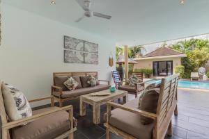 uma sala de estar com um sofá e cadeiras e uma piscina em Beautiful Huge 4 bedrooms Villa in Canggu em Canggu