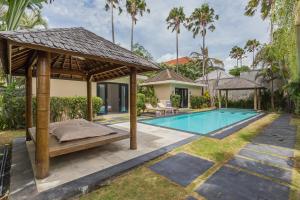 a bed in a gazebo next to a swimming pool at Beautiful Huge 4 bedrooms Villa in Canggu in Canggu
