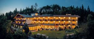 a large building on a hill with lights at APIPURA hotel rinner in Soprabolzano