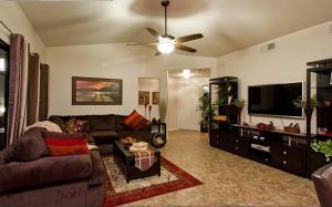 a living room with a couch and a flat screen tv at Central Location, Heated Pool, Bbq, Hot Tub, More in Scottsdale