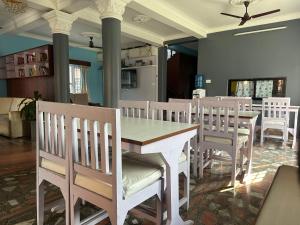 ein Esszimmer mit einem weißen Tisch und Stühlen in der Unterkunft Hotel The Billabong Garden Pokhara in Pokhara + 28 Fotos