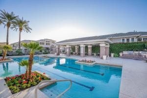 a swimming pool with palm trees and a house at Scottsdale Vacation Rentals in Scottsdale