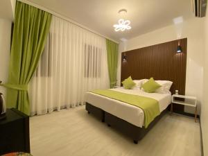 ein Schlafzimmer mit einem großen Bett mit grüner Bettwäsche in der Unterkunft My Dream Bozcaada in Bozcaada