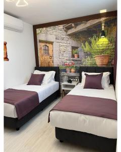 een slaapkamer met 2 bedden en een stenen muur bij My Dream Bozcaada in Bozcaada