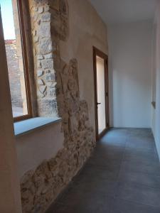 pasillo con pared de piedra y ventana en Cal Vallverdú - Adaptado, en Preixana