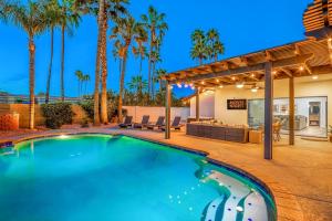 鳳凰城的住宿－Scottsdale Vacation Rentals，棕榈树房子后院的游泳池