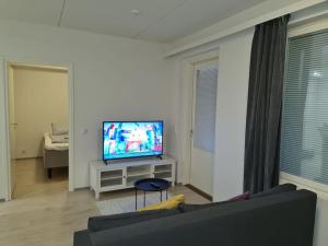 a living room with a couch and a flat screen tv at MR Apartments 6 in Vaasa