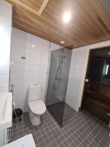 a bathroom with a shower and a toilet and a sink at MR Apartments 6 in Vaasa