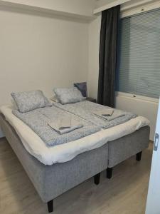 a bedroom with a bed with two pillows and a window at MR Apartments 6 in Vaasa