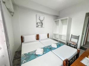 2 camas en una habitación pequeña con silla en Gplace Hotel, en Cebú