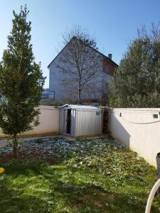 a fence in a yard with a house in the background at La bonne escale in Paray-Vieille-Poste