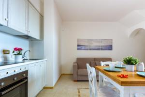 uma cozinha e sala de jantar com mesa e cadeiras em Appartamento Borgo Mari PT5 - MyHo Casa em Santa Teresa Gallura