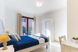 um quarto com uma cama, uma secretária e uma janela em Appartamento Borgo Mari PT5 - MyHo Casa em Santa Teresa Gallura