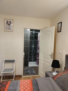 um quarto com uma cama e um chuveiro na casa de banho em La bonne escale em Paray-Vieille-Poste