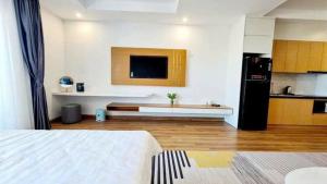 a large room with a kitchen with a bed and a television at Căn Hộ TMS Luxury Apartment - Condotel Quy Nhơn in Quy Nhon