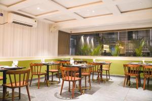 a restaurant with tables and chairs in a room at Ariena by Spree Hotels Goa in Morjim