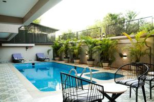 a patio with chairs and a swimming pool at Ariena by Spree Hotels Goa in Morjim
