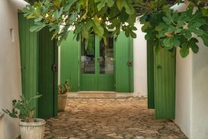 a green door in a building with plants at Trulli Li Cridd in Ceglie Messapica +67 photos