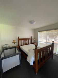 1 dormitorio con cama de madera y ventana en Cowes Holiday Home, en Cowes