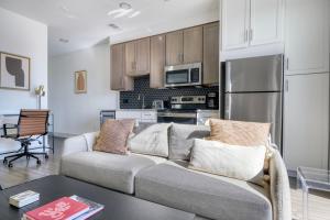 a living room with a couch and a kitchen at Downtown 2br w deck gym nr convention center ATX-211 in Austin