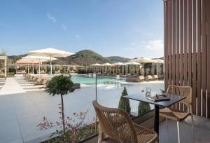a patio with a table and chairs and a pool at Oniro Boutique Hotel in Toroni
