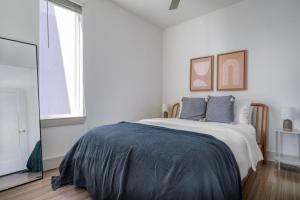 a white bedroom with a bed and a television at Downtown 2br w deck gym nr convention center ATX-211 in Austin