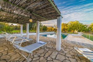 a patio with chairs and a swimming pool at Trulli Li Cridd in Ceglie Messapica