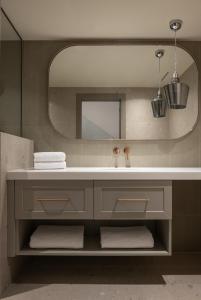 a bathroom with a sink and a mirror at Oniro Boutique Hotel in Toroni