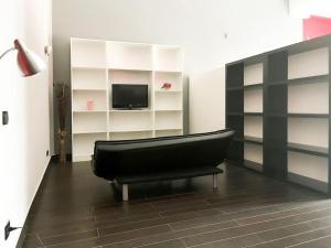 a living room with a black couch and a television at Mini Appartamento Cutura Rende in Rende