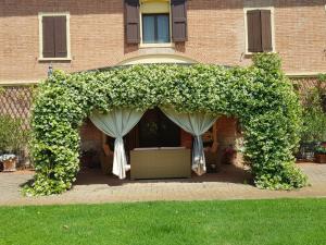 an arch covered in flowers in front of a house at La Villa delle Rose in Carpi