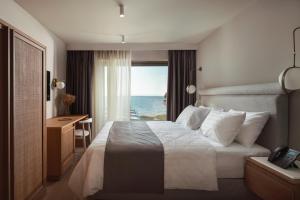 a bedroom with a bed with a view of the ocean at Oniro Boutique Hotel in Toroni