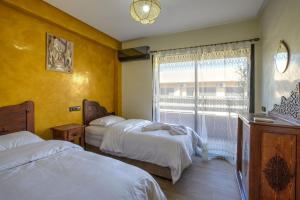 - une chambre avec 2 lits et une fenêtre dans l'établissement Nour 5 el bellar, à Marrakech