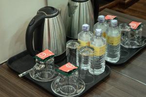 una bandeja con vasos y una jarra de agua en Kusum Airport Hotel, en Katmandú