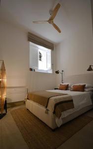 a bedroom with a bed and a ceiling fan at Luxury Apartment in Historic Ortigia, Syracuse in Siracusa