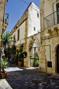an old building with a gate in a courtyard at Luxury Apartment in Historic Ortigia, Syracuse in Siracusa
