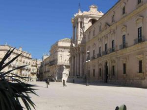 a group of people walking in a courtyard in a building at Luxury Apartment in Historic Ortigia, Syracuse in Siracusa +10 photos