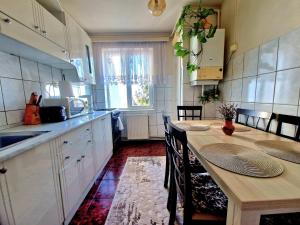 a kitchen with a wooden table and a dining room at Sabina Apartment in Sighişoara