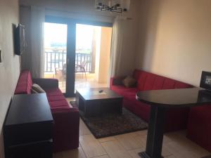 een woonkamer met een rode bank en een tafel bij Aldau Heights in Hurghada